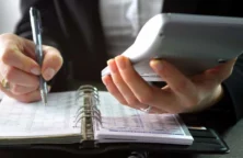 personne avec clculatrice , carnet et stylo