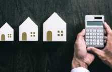 visuel 3 maisons + main tenant une calculatrice(© Adobestock)